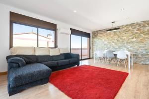 a living room with a couch and a red rug at La Plana in Creixell