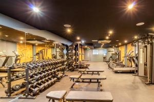 a gym with rows of benches and weights at The Wesley Euston in London