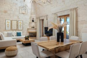 a living room with a wooden table and chairs at Emerald Villas & Suites - The Finest Hotels Of The World in Agios Nikolaos