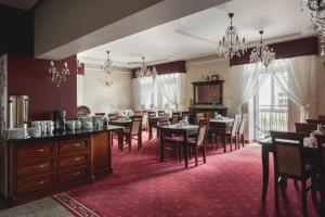 a dining room with tables and chairs and chandeliers at Paria Hotel in Kudowa-Zdrój
