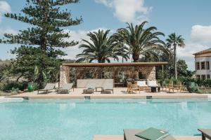 una piscina con sillas y un cenador en Hotel Rural Sant Patrici, en Ferreries