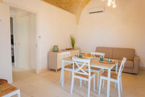 a living room with a table and chairs and a couch at Villa La Rimunda in Otranto