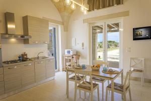 a kitchen and dining room with a table and chairs at Villa La Reimunda in Otranto