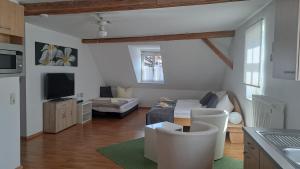 a living room with a couch and a tv at Gasthaus "Garni" Am Viehmarkt in Ummerstadt