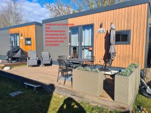 维德宁Tiny House Lohse的一个小房子,配有桌椅和雨伞