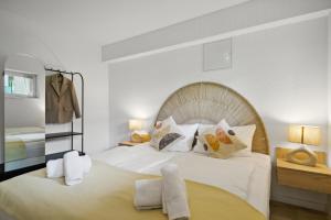 a bedroom with a large bed with white sheets and pillows at Casas Oasis - Modern, mit Küche & Thermennähe in Bad Füssing