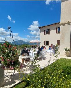 a group of people sitting at tables in front of a building at PALAZZO PALITTI in Poggio