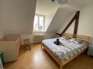 ein Schlafzimmer mit einem Bett und einem Stuhl darin in der Unterkunft BookingAlsace - Maison Mittelharth Parking Jardin in Colmar