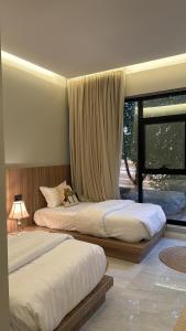 a bedroom with two beds and a large window at Damas Resort in Mezairaa +99 photos