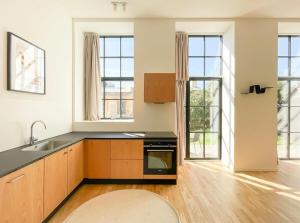 an empty kitchen with a sink and a stove at Cozy and Bright Apartments with Private Car Park in Copenhagen