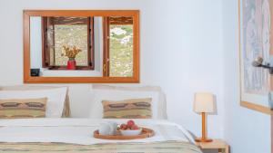 a bed with a tray with a bowl of fruit on it at Lavender Studio in Patmos