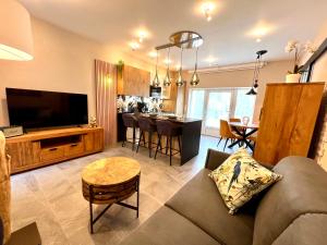 a living room with a couch and a kitchen at Le Clos Saint Lubin in Nainville-les-Roches