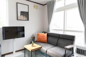 a living room with a couch and a tv at Lavender Breeze Furano 2 in Furano