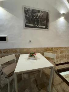 a white table with chairs and a picture on the wall at La Cattedrale in Bisceglie