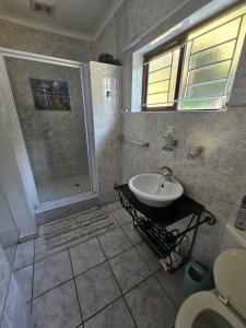 a bathroom with a sink and a shower at Villa Rosseau in Freeland Park +9 photos