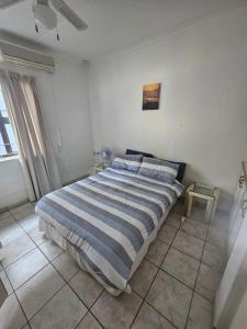 a bedroom with a bed with a blue and white comforter at Villa Rosseau in Freeland Park