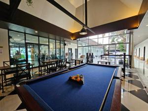 a pool table in a room with tables and chairs at Mercy Hostel in Chiang Rai