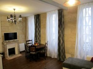 a living room with a table and chairs and a television at Appartements Bordeaux Saint Michel in Bordeaux