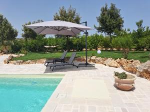 an umbrella and a bench next to a pool at Fogliantica Azienda Agrituristica in Ceglie Messapica