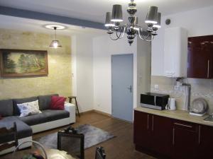 a living room with a couch and a kitchen at Appartements Bordeaux Saint Michel in Bordeaux