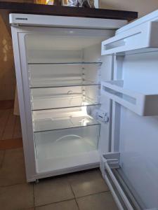 an empty refrigerator with its door open in a kitchen at Casa Alba in Vadstena +21 photos