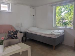 a bedroom with a bed and a couch and a window at Casa Alba in Vadstena