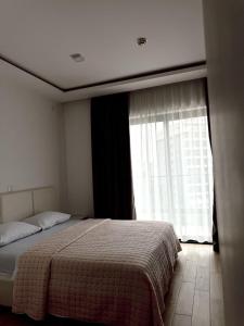 a bedroom with a bed and a large window at Blue Sutomore in Brca