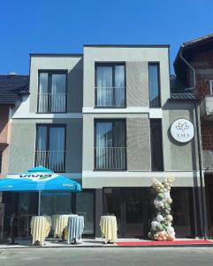 un edificio con sombrilla y sillas delante de él en Lala, en Bosanska Krupa