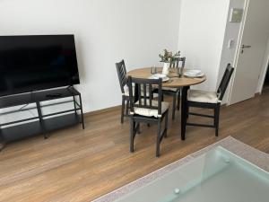 a dining room with a table and chairs and a television at Ferienwohnungen in Borkheide in Borkheide