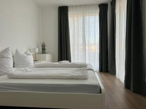 a bedroom with two beds and a large window at Ferienwohnungen in Borkheide in Borkheide