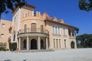 ein großes Gebäude mit einem Balkon auf dem Dach in der Unterkunft Alberg Cabrera de Mar Xanascat in Cabrera de Mar