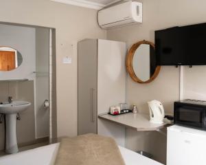a small bathroom with a sink and a microwave at Patterson B&B in Newcastle