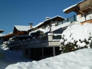 a building covered in snow with a pile of snow at Rene zentrales Studio Appartement - by NV-Appartements in Kirchberg in Tirol