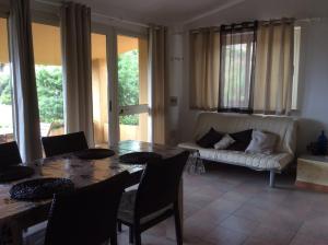 a living room with a table and a couch at Villetta Vista Mare in Costa Paradiso