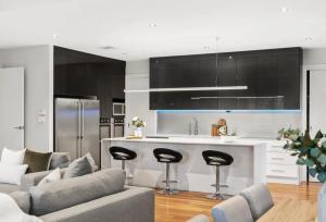 a kitchen and living room with a couch and a counter at Sun room in the European style Luxorious Home in Norwood +7 photos