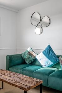 a living room with a green couch and a coffee table at Bella Vista Hôtel, Suites & Maisons in Porticcio