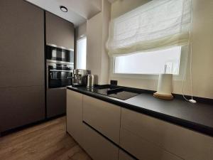 a kitchen with a counter with a sink and a window at Suite Y in Cullera