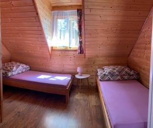 a room with two beds in a wooden cabin at Letnisko Laba in Pobierowo