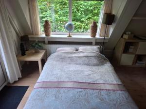 a bed in a bedroom with a large window at Het vlindertje in Durbuy +61 photos