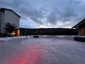 a hot tub with red water in a backyard at Chalet BOGEMA - Sauna, BBQ & Jacuzzi in Beli Iskar