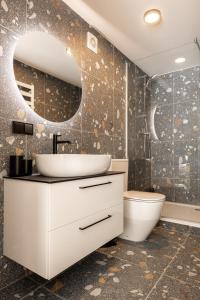 ein Badezimmer mit Waschbecken, Toilette und Spiegel in der Unterkunft Mill Loft in Palanga + 85 Fotos