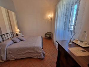 a bedroom with a bed and a desk and a window at PALAZZO PALITTI in Poggio