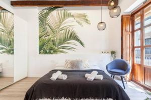 a bedroom with a bed and a blue chair at Modern Flat by Mercado Central in Ciutat Vella in Valencia