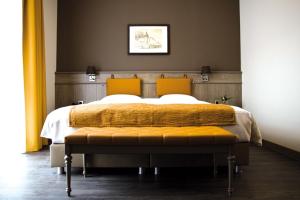 a bedroom with a large bed with two orange pillows at Blanckthys Hotel Voeren in Voeren