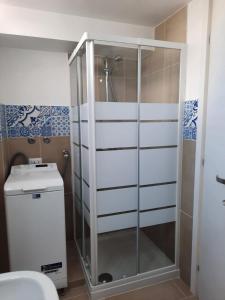 una doccia con una porta in vetro in un bagno di Perla Bianca Elite a Marina di Lizzano