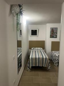 una camera da letto con un letto e uno specchio sul muro di Perla Bianca Elite a Marina di Lizzano