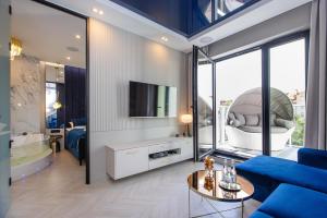 LUNA Luksusowy apartament z jacuzzi na Mazurach في إوك: غرفة معيشة مع أريكة زرقاء وتلفزيون