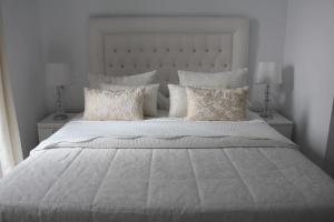 a large white bed with white sheets and pillows at Panther Home Sierpes in Seville