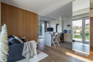 a living room with a blue couch and a kitchen at Marių Veranda in Pervalka
