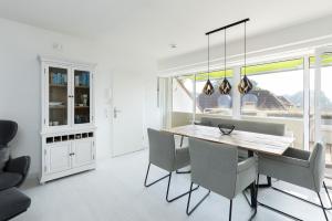 a kitchen and dining room with a table and chairs at Golfresidenz Wohnung 211 in Grömitz